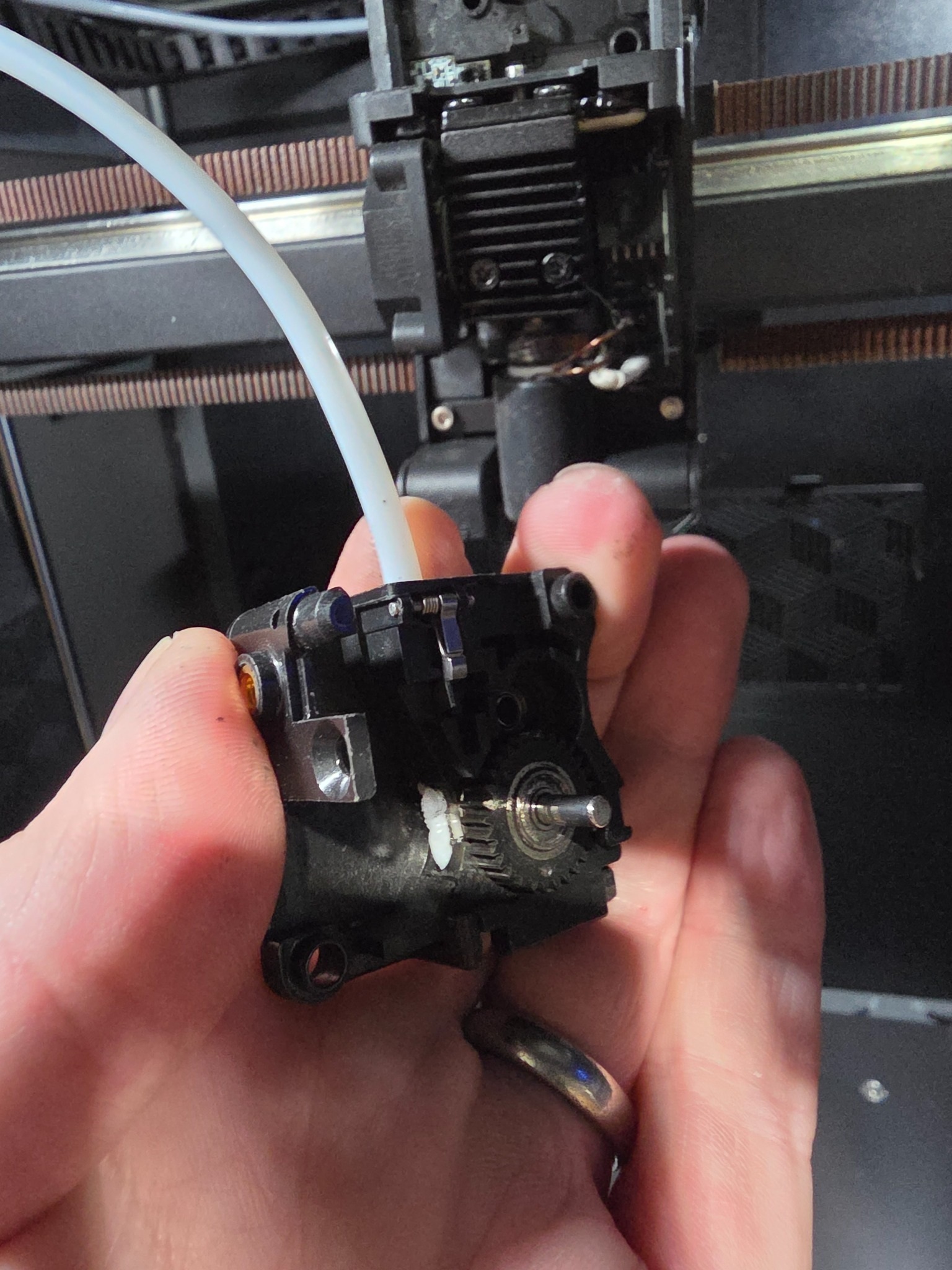 Close-up of a Creality K2 Plus hotend thermal interface during diagnosis of recurring PLA and PETG filament jams.